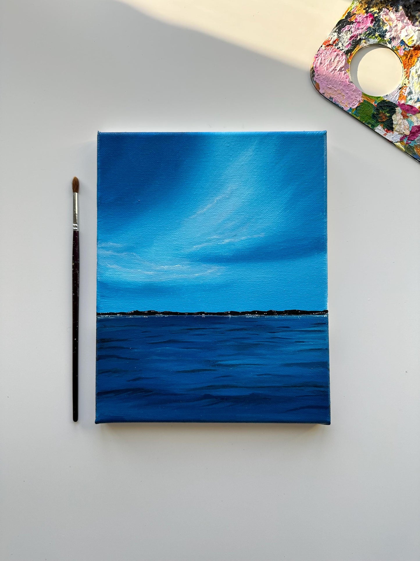 Acrylic painting on stretched canvas with vibrant colors. Ocean art with city lights. Serene artwork for home decor and Christmas gifts.