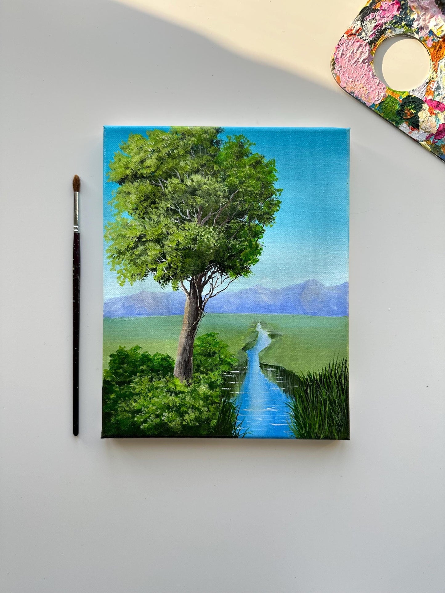 Greenery and mountain landscape acrylic painting on stretched canvas. Made with vibrant colors. Tree by the riverside